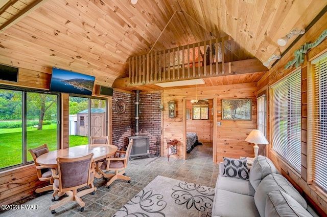 unfurnished sunroom featuring lofted ceiling, a wood stove, and wood ceiling