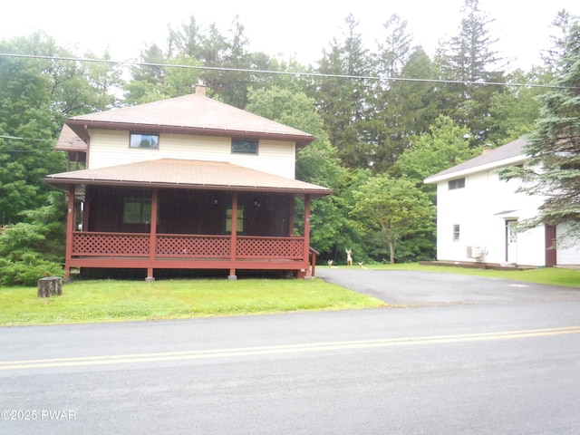 59 Tobyhanna Rd, Gouldsboro, PA 18424 - view of front of property with a front lawn, a chimney, view of wooded area, and driveway