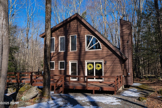 view of front facade with a chimney and a wooden deck