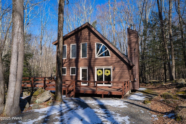 chalet / cabin with a chimney and a deck