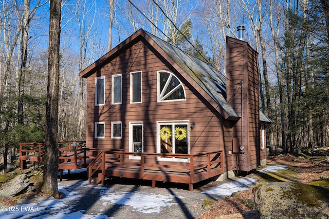 view of front facade with a chimney and a wooden deck