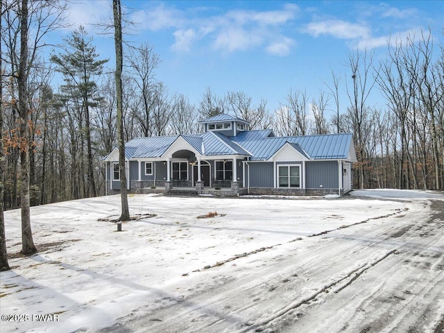 view of front of house with a standing seam roof, a porch, and metal roof