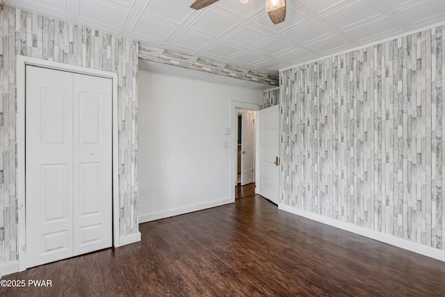 empty room featuring wood finished floors, baseboards, ceiling fan, and an ornate ceiling