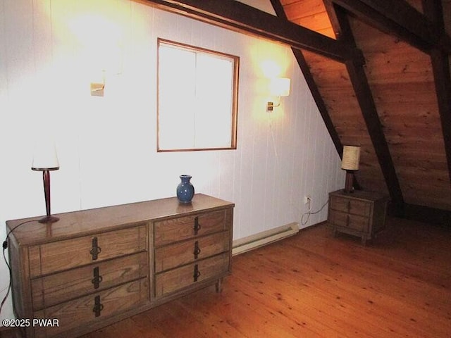 bedroom featuring wood-type flooring, lofted ceiling with beams, and baseboard heating
