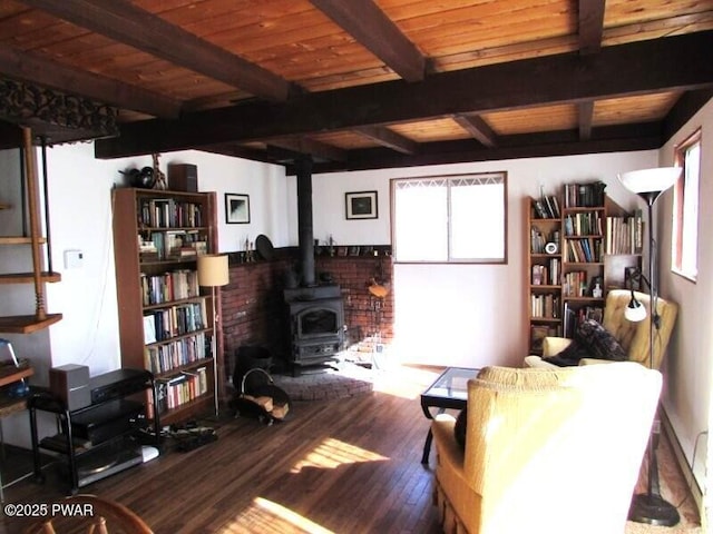 living area featuring a wood stove, wood finished floors, and beamed ceiling