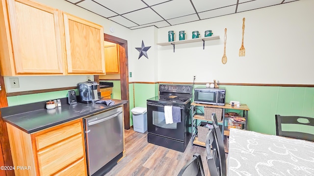 kitchen featuring dishwasher, black electric range oven, a drop ceiling, light brown cabinets, and light hardwood / wood-style flooring