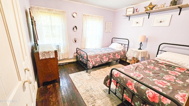 bedroom with crown molding, dark wood-type flooring, and a baseboard heating unit