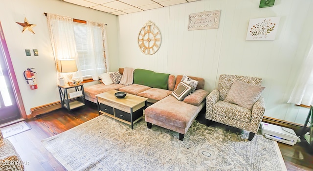 living room featuring hardwood / wood-style floors, wooden walls, and a baseboard radiator