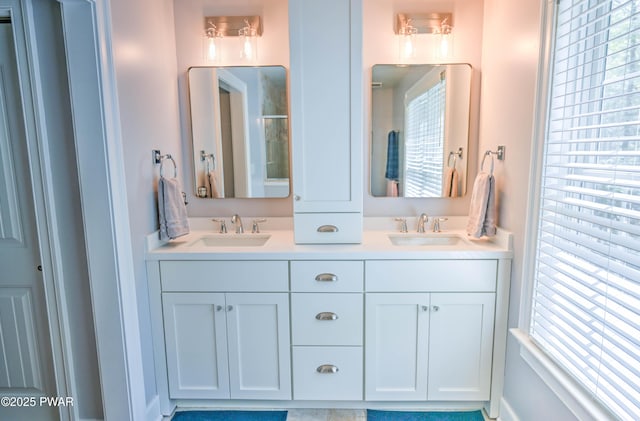 bathroom with double vanity, a sink, and a shower with shower door