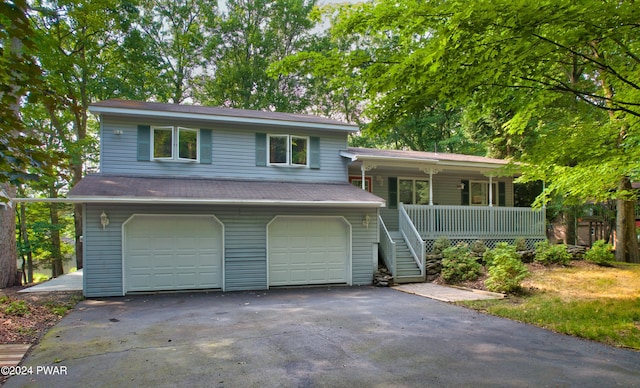 tri-level home featuring covered porch and a garage