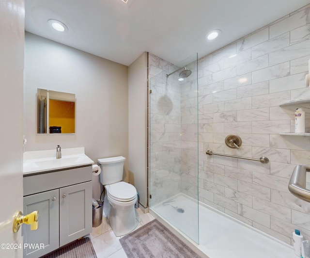 bathroom with toilet, tile patterned flooring, vanity, and tiled shower