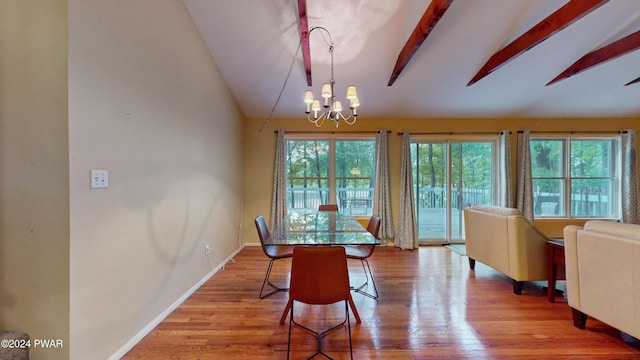 dining room with vaulted ceiling with beams, light hardwood / wood-style floors, and a chandelier