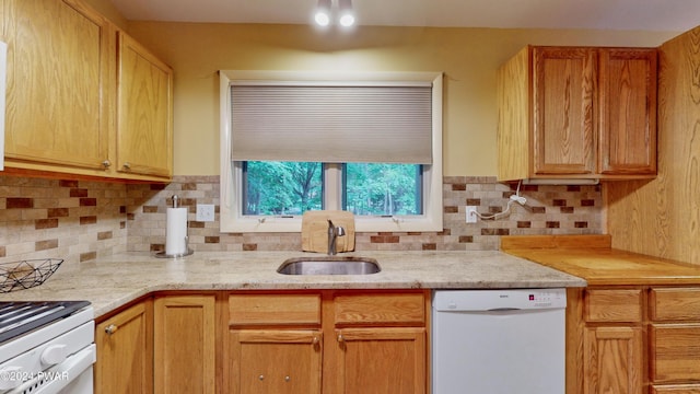 kitchen featuring backsplash, sink, and white dishwasher