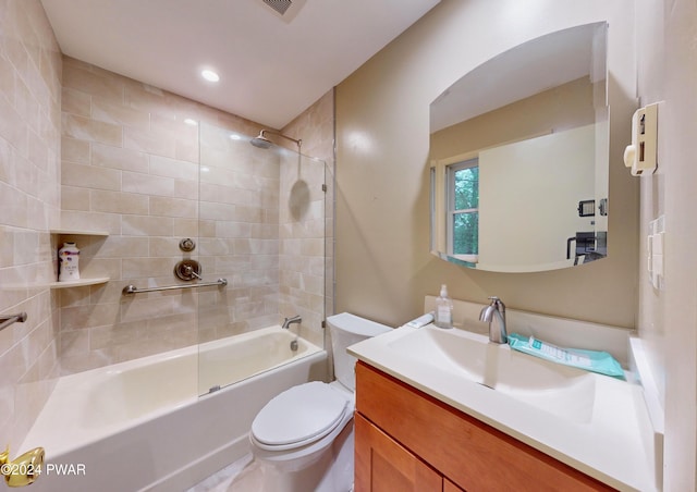 full bathroom featuring toilet, vanity, and tiled shower / bath