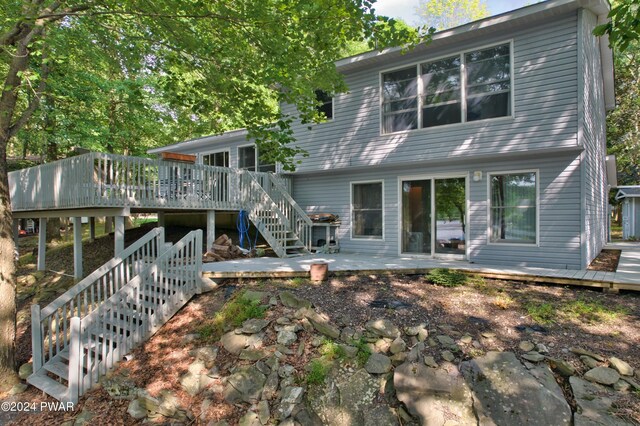 rear view of house featuring a wooden deck