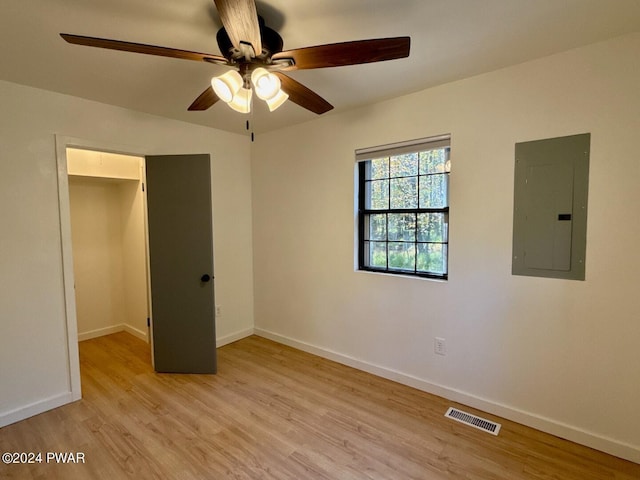 unfurnished bedroom with electric panel, ceiling fan, a closet, and light hardwood / wood-style floors