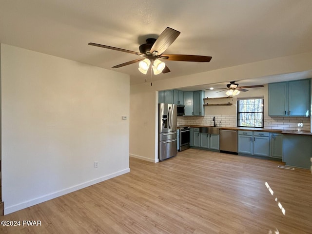 kitchen featuring wooden counters, appliances with stainless steel finishes, backsplash, sink, and light hardwood / wood-style flooring