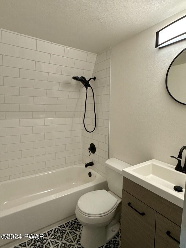 full bathroom with vanity, tile patterned floors, tiled shower / bath combo, toilet, and a textured ceiling