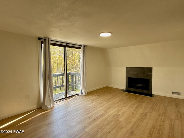 unfurnished living room with light hardwood / wood-style floors and a tile fireplace