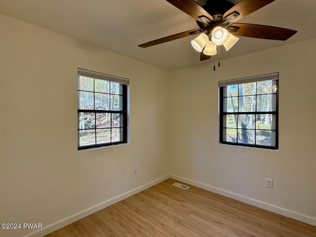 unfurnished room with ceiling fan and light wood-type flooring