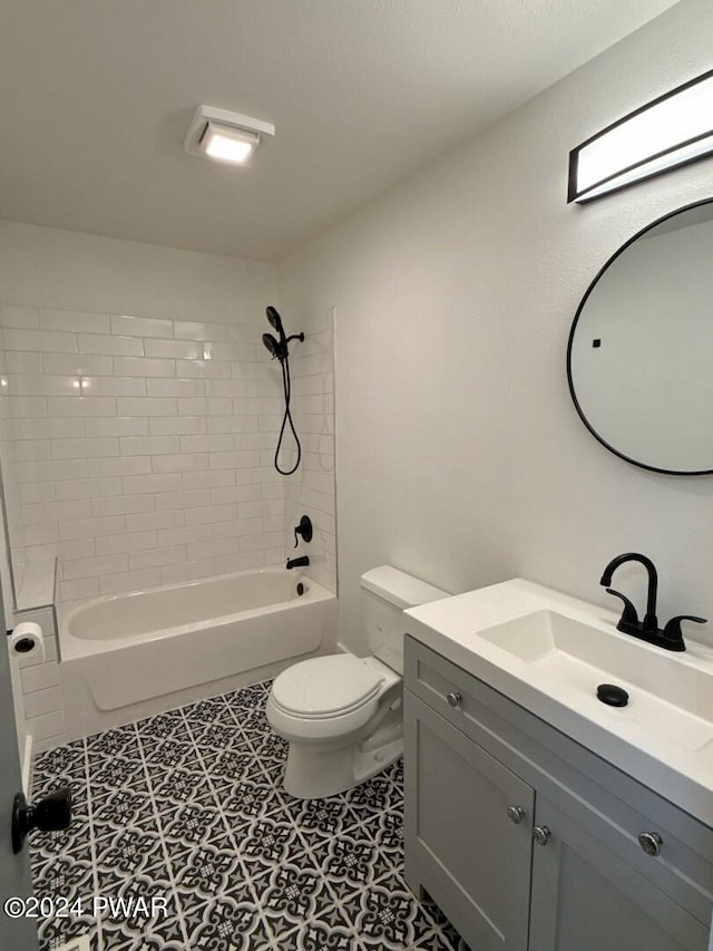 full bathroom with tile patterned floors, vanity, tiled shower / bath combo, and toilet