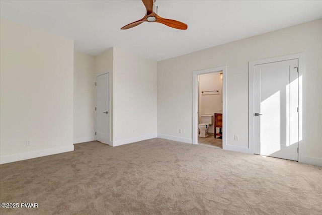 unfurnished bedroom featuring ceiling fan, light carpet, and ensuite bath