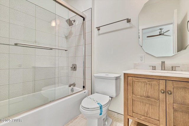 full bathroom featuring ceiling fan, vanity, toilet, and combined bath / shower with glass door