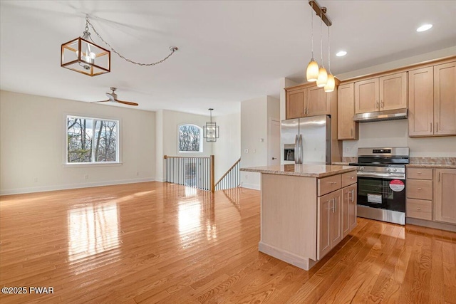 kitchen with pendant lighting, appliances with stainless steel finishes, light brown cabinetry, and a center island