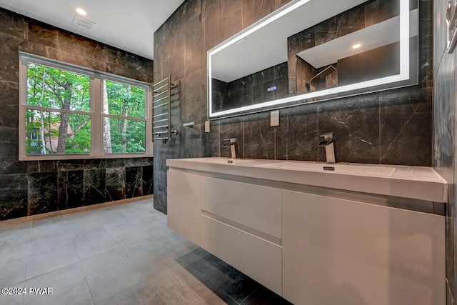 bathroom with vanity, radiator heating unit, and tile walls