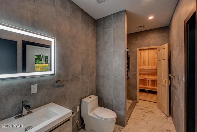 bathroom featuring vanity, toilet, walk in shower, and tile walls