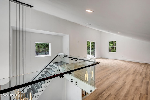 interior space with a healthy amount of sunlight, wood-type flooring, and vaulted ceiling