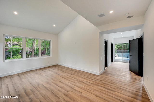 unfurnished room with light hardwood / wood-style floors and lofted ceiling