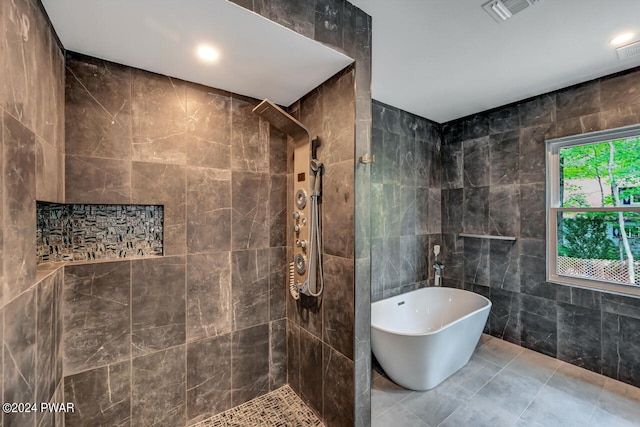 bathroom featuring separate shower and tub and tile walls