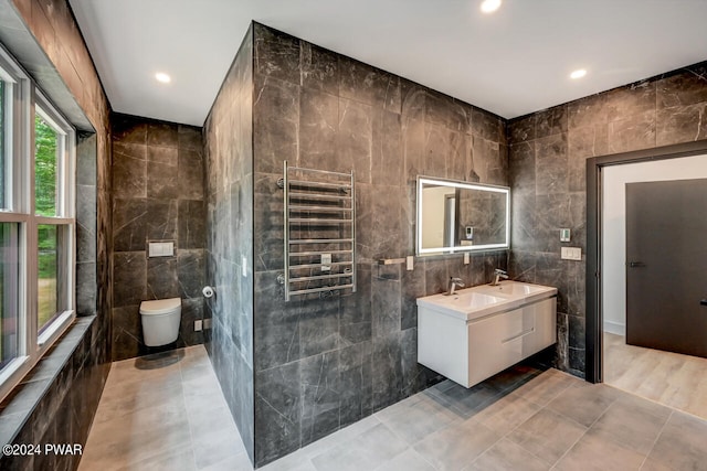 bathroom with vanity, toilet, tile walls, and radiator