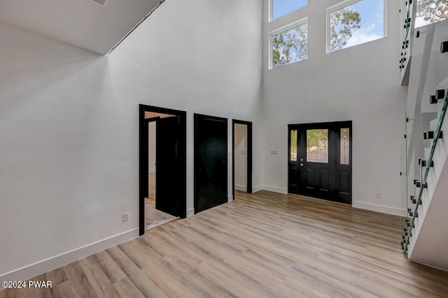 foyer entrance with a high ceiling and light wood-type flooring