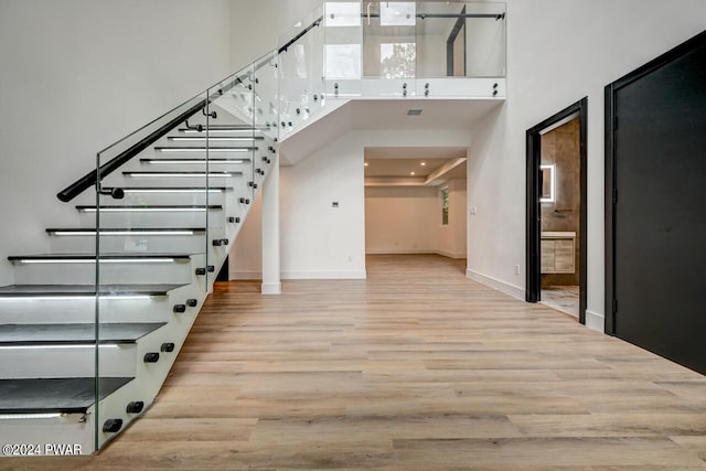 foyer entrance with a towering ceiling and light hardwood / wood-style flooring