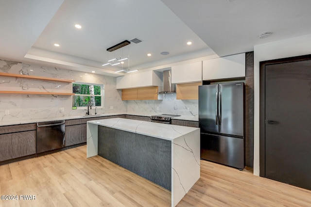 kitchen with light stone countertops, stainless steel appliances, pendant lighting, white cabinets, and a kitchen island