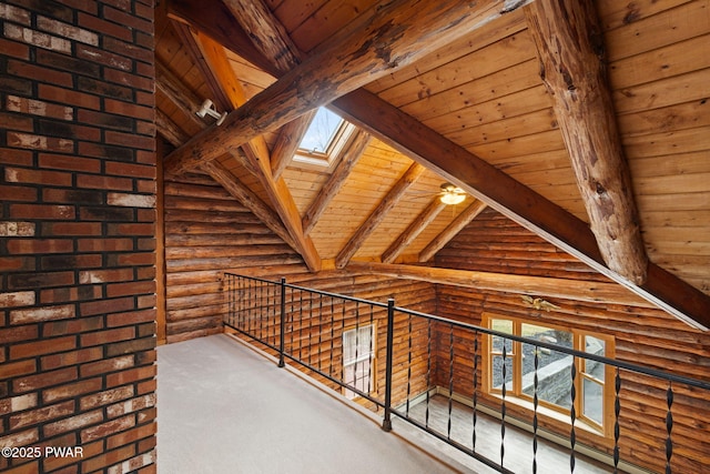 hall with rustic walls, a skylight, beamed ceiling, high vaulted ceiling, and wood ceiling