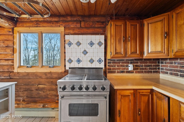 kitchen with light tile patterned flooring, wood ceiling, stainless steel stove, and log walls