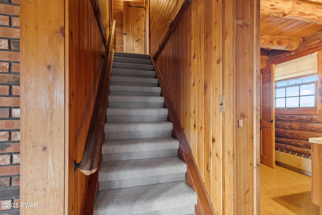 stairway featuring rustic walls, wooden walls, carpet floors, and wood ceiling