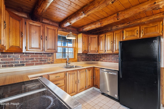 kitchen with beam ceiling, dishwasher, sink, decorative light fixtures, and black refrigerator