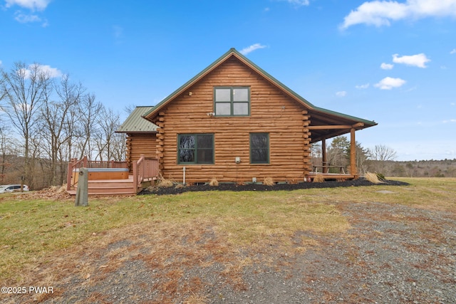 back of house featuring a wooden deck and a lawn