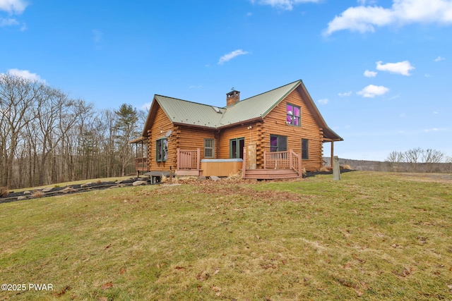 back of property with a yard, a hot tub, and a deck