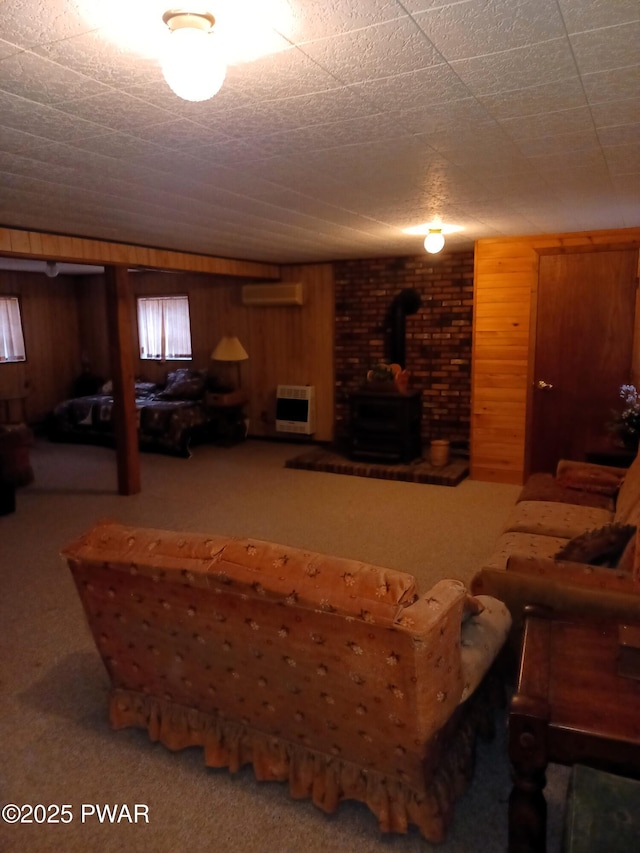 carpeted living room with wood walls, a wood stove, an AC wall unit, and heating unit