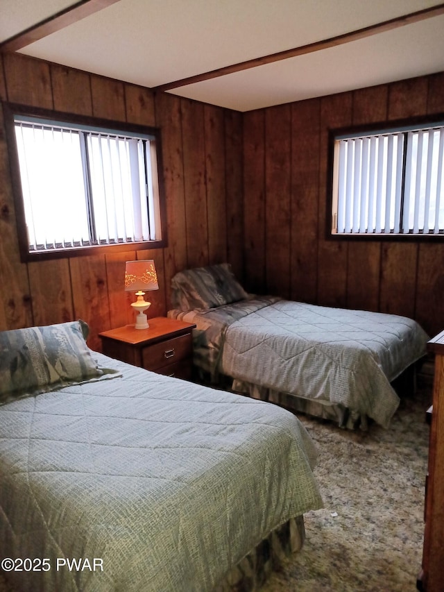 carpeted bedroom featuring wooden walls