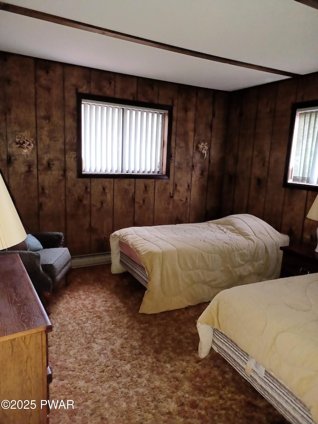 carpeted bedroom featuring baseboard heating and wood walls