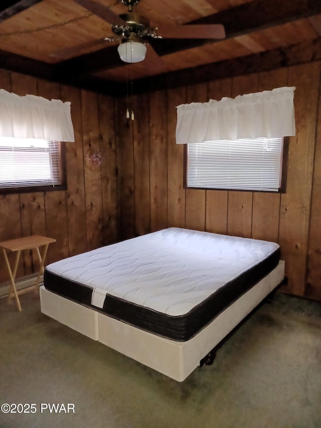 bedroom featuring wooden walls, carpet, wood ceiling, and ceiling fan