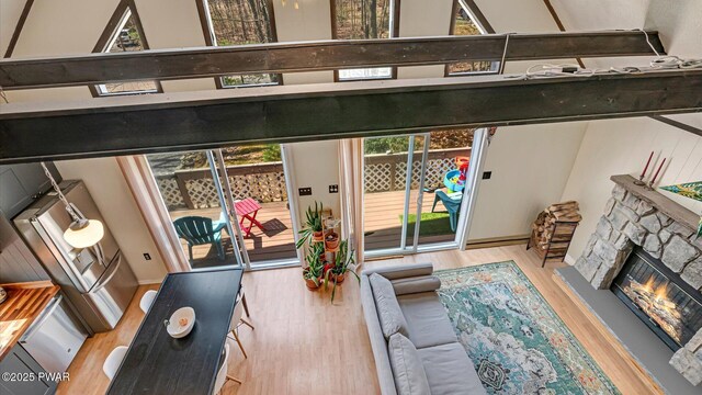 living area featuring a stone fireplace and light wood finished floors