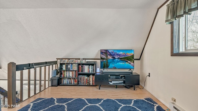 exterior space featuring a textured ceiling, a baseboard radiator, and wood finished floors