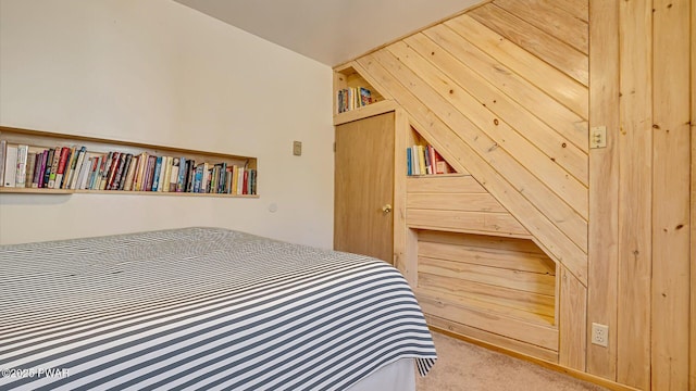 carpeted bedroom with wood walls